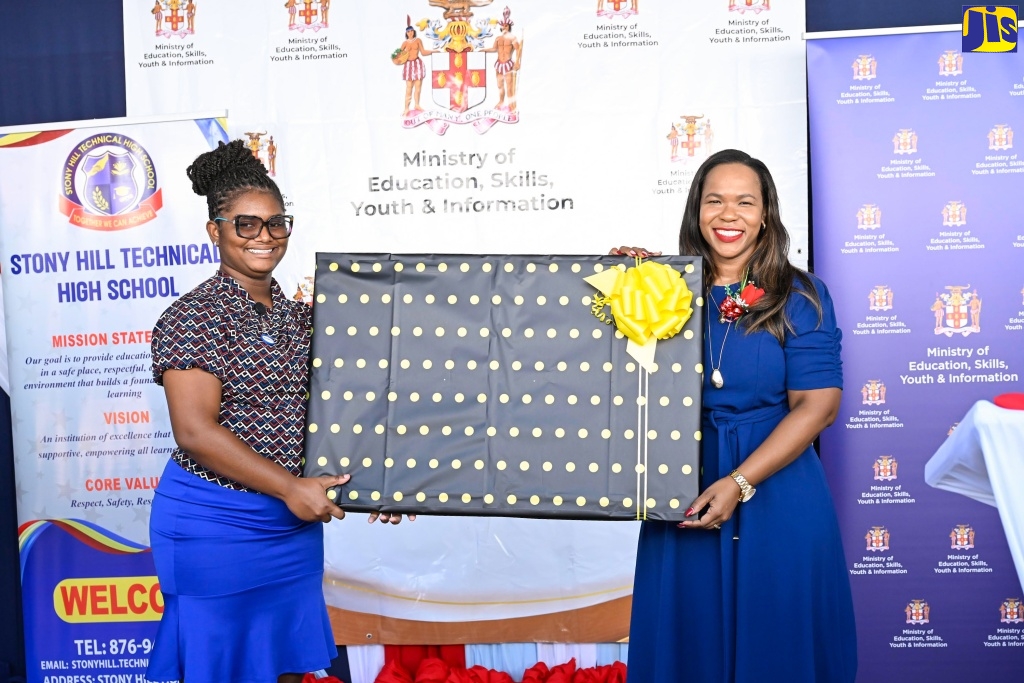Permanent Secretary in the Ministry of Education, Skills, Youth and Information, Dr. Kasan Troupe (right), receives a token from Stony Hill Technical High School teacher, Oneisha Lawrence, during the official opening of an Electronic Document Preparation and Management (EDPM) and Customer Engagement Laboratory at the institution in St. Andrew on Friday (January 9).