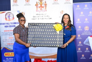 Permanent Secretary in the Ministry of Education, Skills, Youth and Information, Dr. Kasan Troupe (right), receives a token from Stony Hill Technical High School teacher, Oneisha Lawrence, during the official opening of an Electronic Document Preparation and Management (EDPM) and Customer Engagement Laboratory at the institution in St. Andrew on Friday (January 9).

