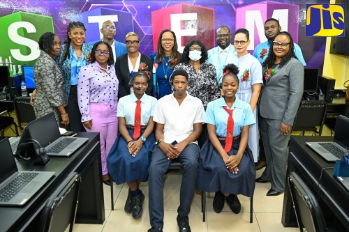 Permanent Secretary in the Ministry of Education, Skills, Youth and Information, Dr. Kasan Troupe (centre, standing), and State Minister in the Ministry of National Security and Peace and Member of Parliament for St. Andrew West Rural, Hon. Juliet Cuthbert Flynn (fifth left, standing), join stakeholders and students for a photo in the new Electronic Document Preparation and Management (EDPM) and Customer Engagement Laboratory at Stony Hill Technical High School in St. Andrew, during the official opening on Friday (January 9).
