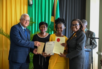 Minister of Justice and Constitutional Affairs, Hon. Delroy Chuck (left); High Court Judge, Hon. Sonia Bertram Linton (second left); and Custos of St. Thomas, Marcia Bennett (right), present new Justice of the Peace (JP) for St. Thomas, Patricia Grant, with her documents of office, during a recent commissioning ceremony for JPs for the parish held at the Whispering Bamboo Cove Resort.

