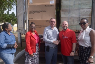 Minister of Energy, Telecommunications and Transport, Hon. Daryl Vaz (centre), greets Chief Executive Officer of Digicel Jamaica, Stephen Murad (second right), at the handover of hurricane relief supplies to the Office of Disaster Preparedness and Emergency Management (ODPEM) on Friday (January 16), at the Garmex Free Zone on Marcus Garvey Drive in Kingston. Also in attendance (from left) are Chief Executive Officer of the Digicel Foundation, Charmaine Daniels; Senior Director, Mitigation, Planning and Research at ODPEM, Michelle Edwards; and Director of Corporate and Government Relations at Digicel, Joy Clark.