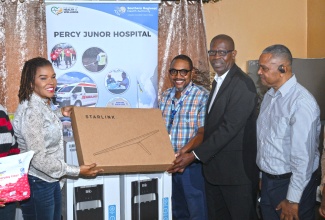 Minister without portfolio in the Office of the Prime Minister with Responsibility for Efficiency, Innovation, and Digital Transformation, Ambassador the Hon. Audrey Marks, who is also Member of Parliament for Manchester North Eastern, presents a Starlink unit to Senior Medical Officer (SMO) at the Percy Junor Hospital, Dr. Carlos Wilson (second left), and Chief Executive Officer, Carlton Nichols (second right). Occasion was the handover of several items at the hospital on Friday (January 16), which will also benefit the adjoining Spalding Health Centre. Looking on is Chairman of the Southern Regional Health Authority (SRHA), Michael Stern. 

