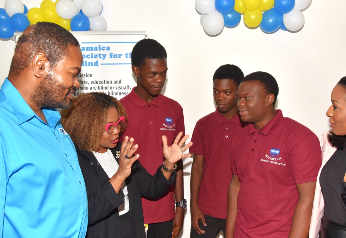 Minister of Education, Skills, Youth & Information, Senator Dr. the Hon. Dana Morris Dixon (second left), engages HEART/NSTA Trust trainees (from third left) James Hamilton, André Bender and Kevaughn Williams, during the handover ceremony for the Trust’s Region 1 National Development Project, at the Jamaica Society for the Blind in Kingston, on Thursday (January 15). Also pictured are Chairman of the Jamaica Society for the Blind, Damion McLean  and Managing Director of the HEART/NSTA Trust, Dr. Taneisha Ingleton.

