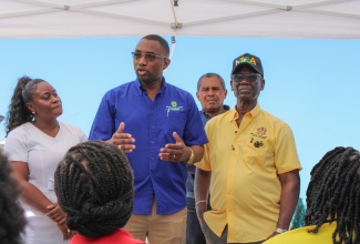 Minister of Local Government and Community Development, Hon. Desmond McKenzie (right), listens as Executive Director of the Social Development Commission (SDC), Omar Frith (second left), addresses staff of the Trelawny Infirmary during a recent psychosocial intervention session. Also listening (from left) are Matron at the Infirmary, Tracey-Ann Bell, and Councillor for Sherwood Division in Trelawny, Dunstan Harper.

