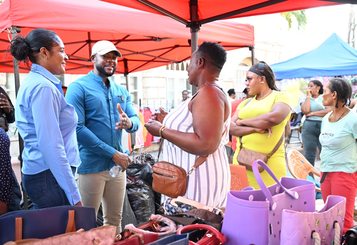 Mayor of Montego Bay and Chairman of the St. James Municipal Corporation, Councillor Richard Vernon, along with Chief Executive Officer, Naudia Crosskill (left), engages vendor, Minorah Robinson (centre), and others during a visit with vendors across downtown Montego Bay on Friday (January 9).

