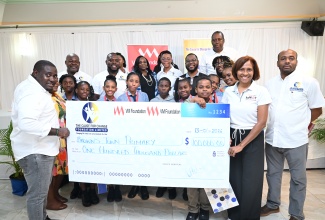 Principal Director of Cause for Change Foundation Limited, Richardo Aiken (left) and Chief Executive Officer of VM Foundation, Samantha Charles (second right), present the winning cheque to students of Brown