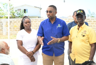 Minister of Local Government and Community Development, Hon. Desmond McKenzie (right), listen to Executive Director of the Social Development Commission (SDC), Omar Frith, during a tour of the site of the new Trelawny Infirmary in Falmouth, on Thursday, January 15. At left  is Matron of the Trelawny Infirmary, Tracey-Ann Bell.

