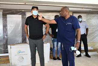 Health and Wellness Minister, Dr. the Hon. Christopher Tufton (left), in discussion with Senior Medical Officer at the Cornwall Regional Hospital, Dr Curtis Yeates, as he tours wards being renovated, on Saturday, January 24.

