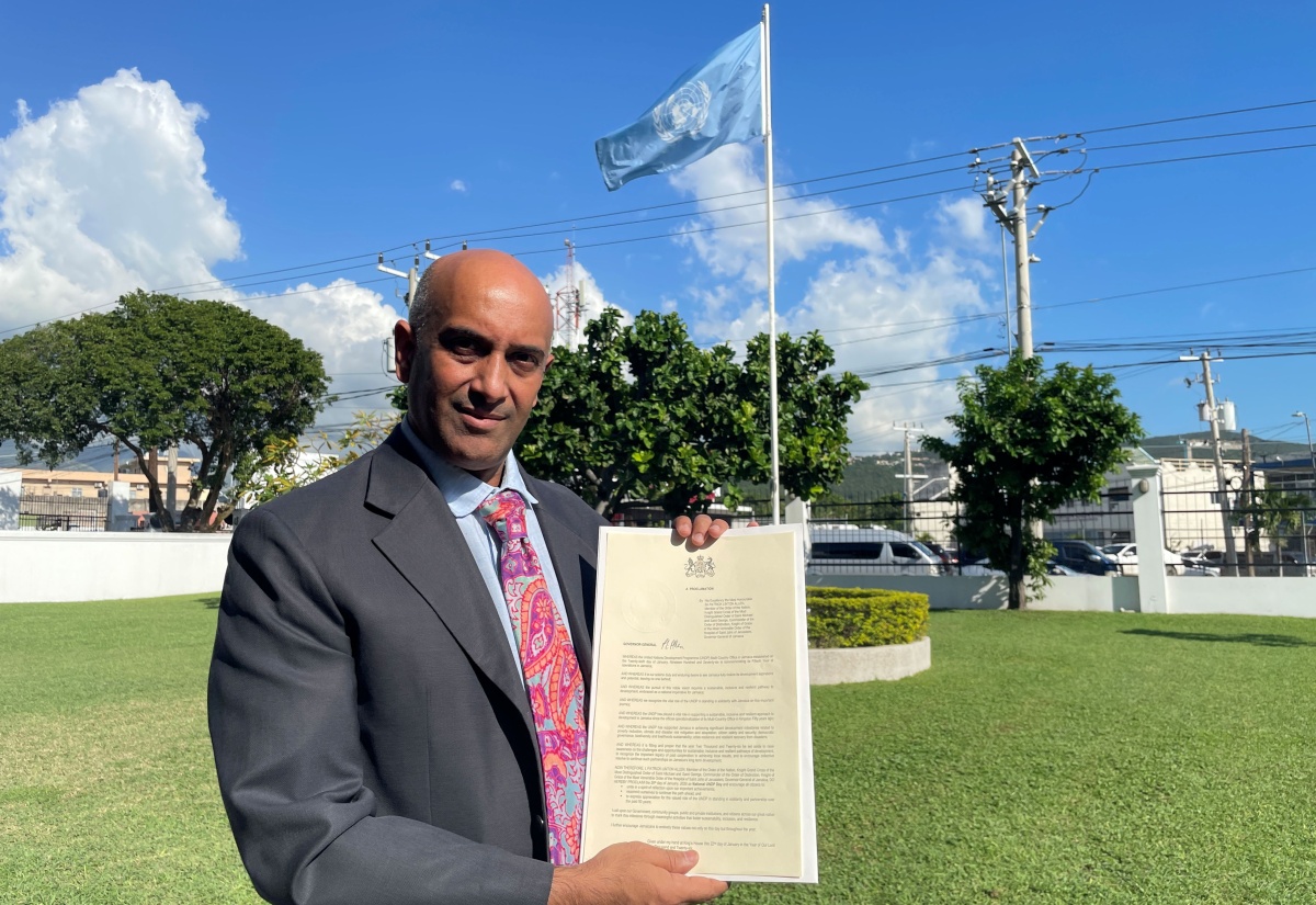 Resident Representative at the United Nations Development Programme (UNDP) Multi-Country Office in Jamaica, Dr. Kishan Khoday, displays the Proclamation for National UNDP Day.

