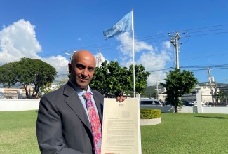 Resident Representative at the United Nations Development Programme (UNDP) Multi-Country Office in Jamaica, Dr. Kishan Khoday, displays the Proclamation for National UNDP Day.


