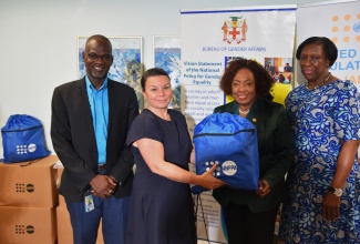 Minister of Culture, Gender, Entertainment and Sport, Hon. Olivia Grange (second right), accepts a dignity kit from United Nations Population Fund (UNFPA) Caribbean Deputy Director and Officer-in-Charge, Jenny Karlsen, during a recent handover of Hurricane Melissa relief supplies at the Ministry’s headquarters in New Kingston. The Bureau of Gender Affairs received 1,000 kits containing hygiene essentials for women and girls. Also sharing the moment are Permanent Secretary in the Ministry, Denzil Thorpe and BGA Principal Director, Sharon Coburn Robinson.