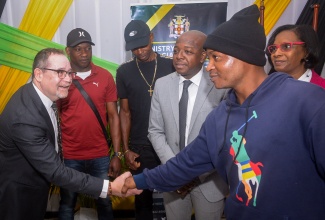 Minister of Labour and Social Security, Hon. Pearnel Charles Jr. (third right), and Acting Permanent Secretary in the Ministry, Dione Jennings (right), look on as Canada’s High Commissioner to Jamaica, His Excellency Mark Berman (left), greets first-time farm worker, 24-year-old André Hollinzed (second right). Occasion was a send-off ceremony for seasonal agricultural workers to Canada, held at the Ministry’s Overseas Employment Centre on East Street in downtown Kingston on January 6. Sharing the moment from (second left) are farm workers André Ellis and Arnold Campbell. 

