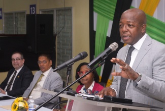 Minister of Labour and Social Security, Hon. Pearnel Charles Jr. (right), addresses a send-off ceremony for seasonal agricultural workers departing for Canada, held at the Ministry’s Overseas Employment Centre on East Street in downtown Kingston on Tuesday (January 6). Listening (from left) are Canada’s High Commissioner to Jamaica, His Excellency Mark Berman; State Minister in the Ministry of Labour and Social Security, Hon. Donovan Williams; and Acting Permanent Secretary, Dione Jennings.

