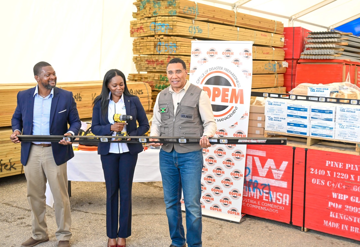 Prime Minister, Dr. the Most Hon. Andrew Holness (right), displays a level, which was among tools and building supplies donated by New Era Developments Limited and Kemtek Construction, at the Jamaica Defence Force (JDF) Forward Operating Base in Luana, St. Elizabeth on Friday (Jan. 16). He is joined by Director General, Office of Disaster Preparedness and Emergency Management (ODPEM), Commander Alvin Gayle and President, New Era Developments Limited, Antonette Taddeo.