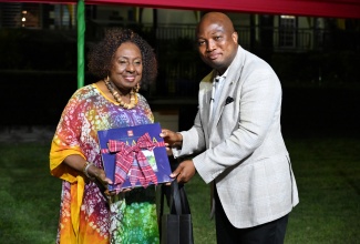 Minister of Culture, Gender, Entertainment and Sport, Hon. Olivia Grange (left), presents a gift to Minister of Foreign Affairs of the Republic of Ghana, His Excellency Samuel Okudzeto Ablakwa. Occasion was a welcome reception and tour at the Seville Great House in St. Ann, on Sunday (January 25). The event formed part a of visit to the island by a Ghanaian delegation headed by Mr. Ablakwa. 

