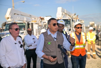 Prime Minister, Dr. the Most Hon. Andrew Holness (centre), addresses the commissioning of over 200 vehicles and equipment by the Jamaica Public Service (JPS) Company at the entity