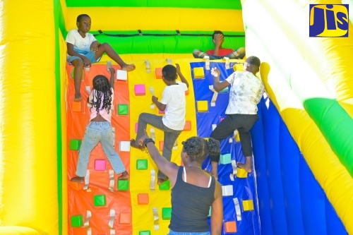 Children enjoy a climbing wall during the Kiddies Treat segment of the Urban Development Corporation's (UDC) Fireworks Festival held at the Long Bay Beach Football Field in Negril, Westmoreland on Wednesday (Dec. 31).