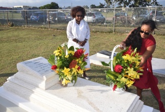 Minister of Culture, Gender, Entertainment and Sport, Hon. Olivia Grange (left), looks on as Member of Parliament for St. James Southern and Opposition Spokesperson on Culture, Creative Industries and Information, Nekeisha Burchell, lays a wreath on the grave of late reggae icon Dennis Brown. The wreath-laying ceremony was held at the National Heroes Park in Kingston on February 1, to commemorate the 69th birthday anniversary of the ‘crown prince of reggae’.

