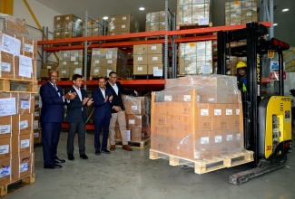 Minister of Industry, Investment and Commerce, Senator the Hon. Aubyn Hill (left), applauds as the first shipment of pharmaceutical items from Dr. Reddy’s Laboratories in Jamaica, destined for Guyana and Trinidad, is being lifted for loading on a truck.  Occasion was a tour of the Dr. Reddy’s warehouse at 109 Marcus Garvey Drive, Kingston, on Thursday (February 5). The Minister is joined by (from left) Caribbean Head, Dr. Reddy’s Laboratories, Preet Darshi Patnaik; First Attaché (Administration and Commerce) from the High Commission of India, Hansraj Chhilwar; and General Manager, T. Geddes Grant, Christopher Curtis.

