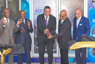 Prime Minister, Dr. the Most Hon. Andrew Holness (centre), cuts the ribbon to officially open the University of Technology (UTech) Lloyd Carney Foundation IMEK Laboratory on Tuesday (February 10), during a ceremony at the university’s Papine campus in St. Andrew. He is assisted by the University’s Chancellor and Chairman for the Foundation, Ambassador Lloyd Carney (second right). Sharing in the moment are (from left) UTech, Jamaica’s President, Dr. Kevin Brown; Minister of Industry, Investment and Commerce, Senator the Hon. Aubyn Hill, and Utech’s Pro-Chancellor, Aldrick McNab. The state-of-the-art Science, Technology, Engineering, and Mathematics (STEM) laboratory, valued over US$1 million, is a makerspace for students to design solutions for real-world problems.