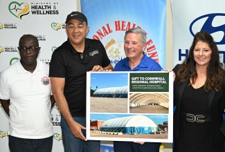 Minister of Health and Wellness, Dr. Hon. Christopher Tufton (second left), is joined by (l-r) Chief Executive Officer (CEO) of the National Health Fund (NHF), Everton Anderson; CEO and Founder of Judah 1, Everett Aaron; and Chief Operating Officer at Kennedy International Logistics and Services, Christie Hutcherson, in displaying images of the medical dome, which will be erected on the grounds of the Cornwall Regional Hospital (CRH) in Montego Bay, St. James, The occasion was a media briefing held at the Western Regional Health Authority (WRHA) Technical Office at the Freeport Business Centre in St. James on Saturday (Feb. 7).