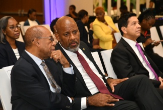 Director General of the Planning Institute of Jamaica (PIOJ), Dr. Wayne Henry (centre), in discussion with former Director General, Dr. Wesley Hughes, during the hybrid 2026 staging of the agency’s Dialogue for Development Lecture at the AC Hotel by Marriott Kingston on Thursday (February 26). At right is President and Founder of Washington, D.C.-based data analytics and business consulting company, NoBrainerData, Dr. José Miguel Guzmán. The internationally recognised specialist in population dynamics, poverty and climate change adaptation, ageing, and sexual and reproductive health was the featured lecturer at the event.