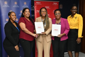 Permanent Secretary in the Ministry of Education, Skills, Youth and Information, Dr. Kasan Troupe (centre), shakes hands with Chief Executive Officer of the Digicel Foundation, Charmaine Daniels (second left), during Monday’s (February 9) Memorandum of Understanding (MOU) signing ceremony for the upgrade of five classrooms at the Mico CARE Centre. The ceremony was held at the Ministry’s Heroes Circle offices in Kingston. The Mico CARE representatives pictured (from left) are Senior Manager and Psychologist, Shelleka Matthews; Director, Dr. Sharon Anderson-Morgan; and Clinical Psychologist/Research and Projects Coordinator, Tisha Ewen-Smith.