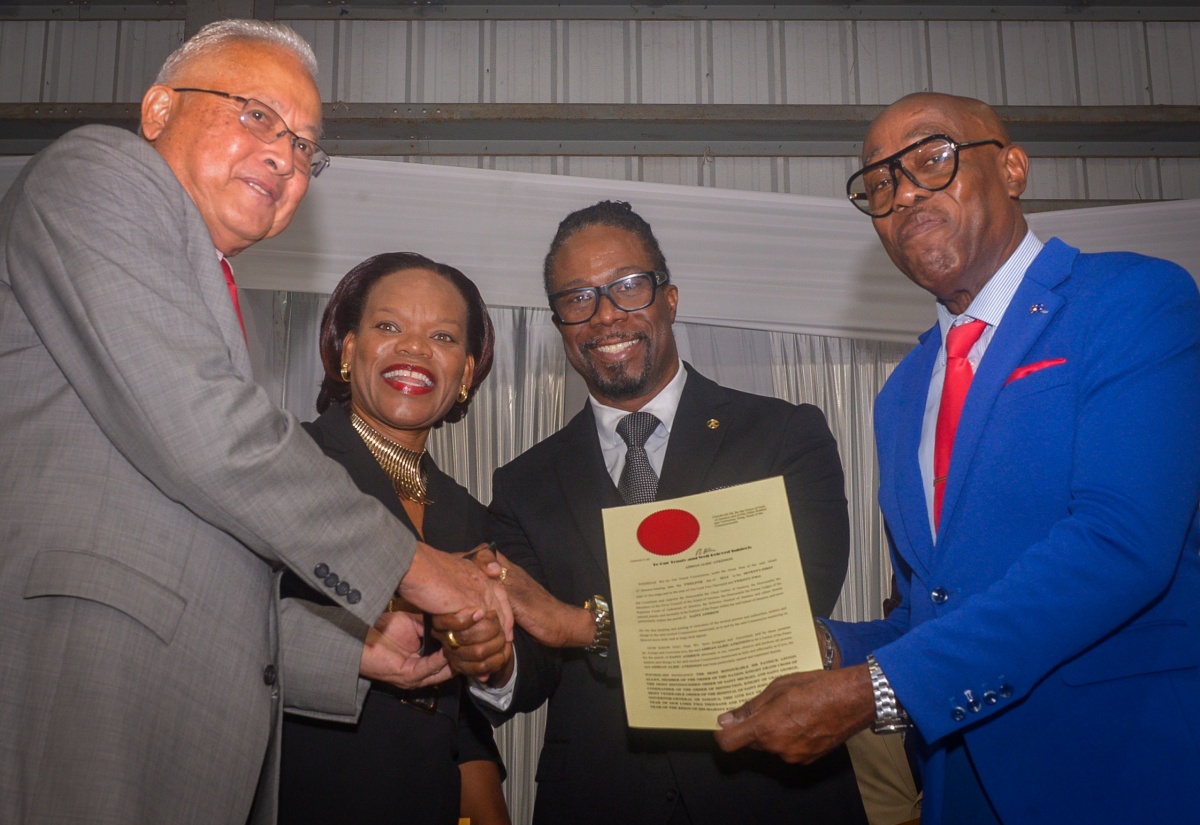 Justice and Constitutional Affairs Minister, Hon. Delroy Chuck (left), shakes hands with newly commissioned Justice of the Peace (JP) for St. Andrew, Adrian Atkinson (second right). He is joined by Principal Director, Justice Training Institute (JTI), Analia Wallace-Muir,  and Custos for St. Andrew, Ian Forbes (right), who presents Mr. Atkinson with the instrument of office. Occasion was the commissioning ceremony of 148 new JPs for St. Andrew on Sunday (February 23) at Jamaica College.

