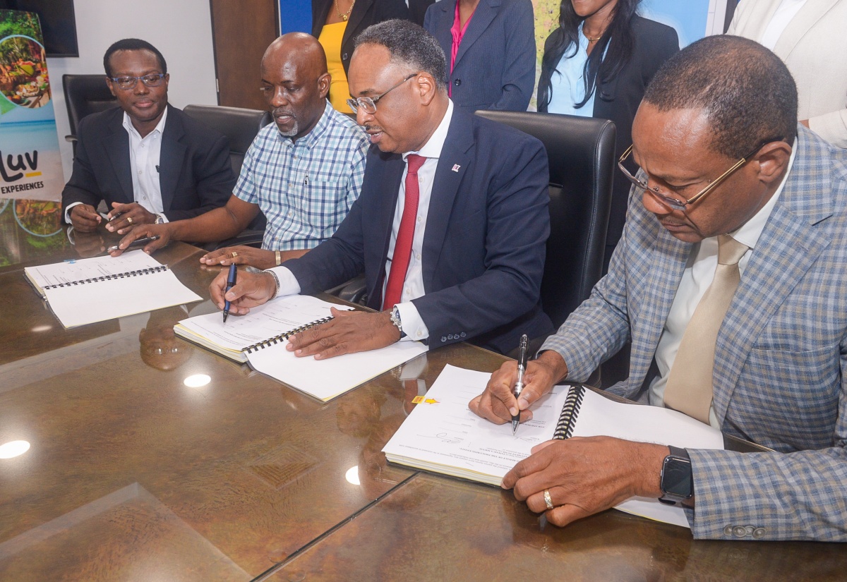 Jamaica Social Investment Fund (JSIF) Managing Director, Omar Sweeney (second right), affixes his signature to the contract to rehabilitate Bath Botanical Gardens in St. Thomas, during Thursday’s (February 5) contract-signing ceremony at JSIF’s Richmond Avenue offices in Kingston. Also participating in the signing (from left) are Chief Technical Director, Special Projects in the Ministry of Agriculture, Fisheries and Mining, Courtney Cole; Project Manager at SM Quality Construction, Roger Smith; and Chief Technical Director in the Ministry of Tourism, David Dobson. 

