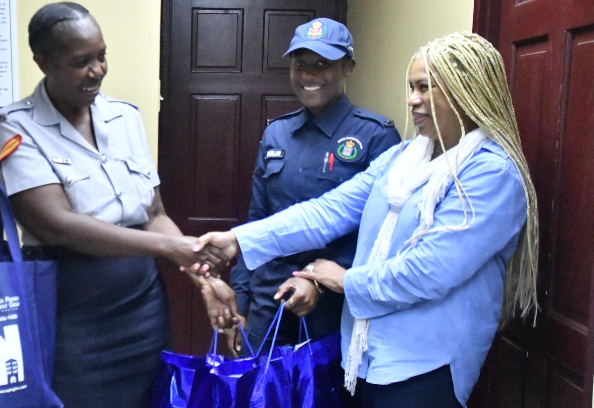 Founder of United States-based diaspora charity, the Pollyanna Project, Donna-Moore Stewart (right), presents gift bags to Corporal Lorraine Hylton of the Lacovia Police Station (left), while Constable Courtney Berlin, shares the moment. The recent presentation, at the police station in St. Elizabeth, was in recognition of the service of the law officers to their communities, particularly in the aftermath of Hurricane Melissa.