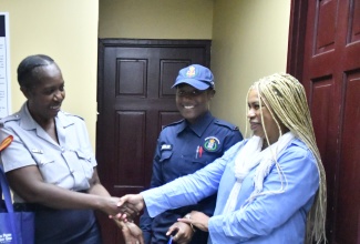 Founder of United States-based diaspora charity, the Pollyanna Project, Donna-Moore Stewart (right), presents gift bags to Corporal Lorraine Hylton of the Lacovia Police Station (left), while Constable Courtney Berlin, shares the moment. The recent presentation, at the police station in St. Elizabeth, was in recognition of the service of the law officers to their communities, particularly in the aftermath of Hurricane Melissa.