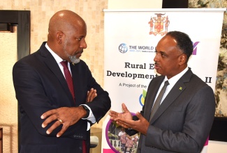 Jamaica Social Investment Fund (JSIF) Chairman, Dr. Wayne Henry (left), engages in discussion with Managing Director, Omar Sweeney, during Tuesday’s (February 17) Contractors and Consultants Procurement Conference at the Jamaica Pegasus Hotel in New Kingston. The conference, which was hosted by JSIF in collaboration with the Public Procurement Commission (PPC), was convened under the theme: ‘Building Partnerships for Stronger Procurement’.