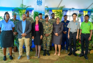 Managing Director of the HEART/NSTA Trust, Dr. Taneisha Ingleton (third left, front row); President, Incorporated Masterbuilders Association (IMAJ), Richard Mullings, (second left, front row); Jamaica Defence Force (JDF) Lieutenant Colonel A Cooper-Nelson, (centre, front row); and Deputy Managing Director National Training and Programmes Division, HEART/NSTA Trust, Dr. Cheryl McLaughlin (third right, front row), share a photo opportunity with members of the JDF, international military personnel and Building Resilience and Inspiring Development through Guided Experience (BRIDGE) Project participants, during the BRIDGE orientation ceremony held at the JDF Camp Site in Luana, St. Elizabeth.

