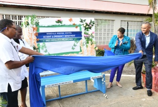 Minister of State, Ministry of Health and Wellness, Hon. Krystal Lee (second right), applauds the unveiling of a new wellness bench at the Mandeville Regional Hospital in Manchester. Removing the cover to reveal the seating are (from left) Chief Executive Officer, Mandeville Regional Hospital, Alwyn Miller; Regional Technical Director, Southern Regional Health Authority (SRHA), Dr. Vitillius Holder; and Chairman-designate, SRHA, Michael Stern. The wellness bench, which will provide relaxation and rejuvenation for persons who visit the hospital, forms part of the Ministry