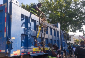 National Solid Waste Management Authority (NSWMA) workers remove old bicycles from the Constant Spring Police Station during a clean-up activity at the facility in St. Andrew on Saturday (February 21).

