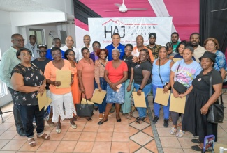 Prime Minister, Dr. the Most Hon. Andrew Holness (centre, backrow) and representatives of the Housing Agency of Jamaica (HAJ), share a moment with new landowners from Westmoreland at the HAJ