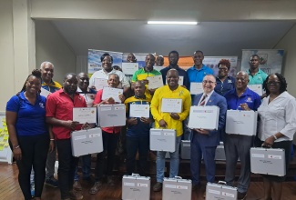 Minister of State in the Ministry of Agriculture, Fisheries and Mining, Hon. Franklin Witter (second right, front row); Canada’s High Commissioner to Jamaica, His Excellency Mark Berman (third right, front row); Senior Director of the Agricultural Land Management Division, Joan Brown-Morrison (right, front row); and Country Coordinator for the World University Service of Canada (WUSC) Caribbean, Nelsa English-Johnson (left, front row), share a photo opportunity with members of the Rural Agricultural Development Authority (RADA) who successfully completed a recent soil management training programme. The initiative was implemented through a partnership between the Agriculture Ministry and the WUSC) Caribbean, with funding from the Government of Canada. The group displays soil testing kits received during the closing ceremony, held on Tuesday (February 17) at the Liguanea Club in New Kingston.