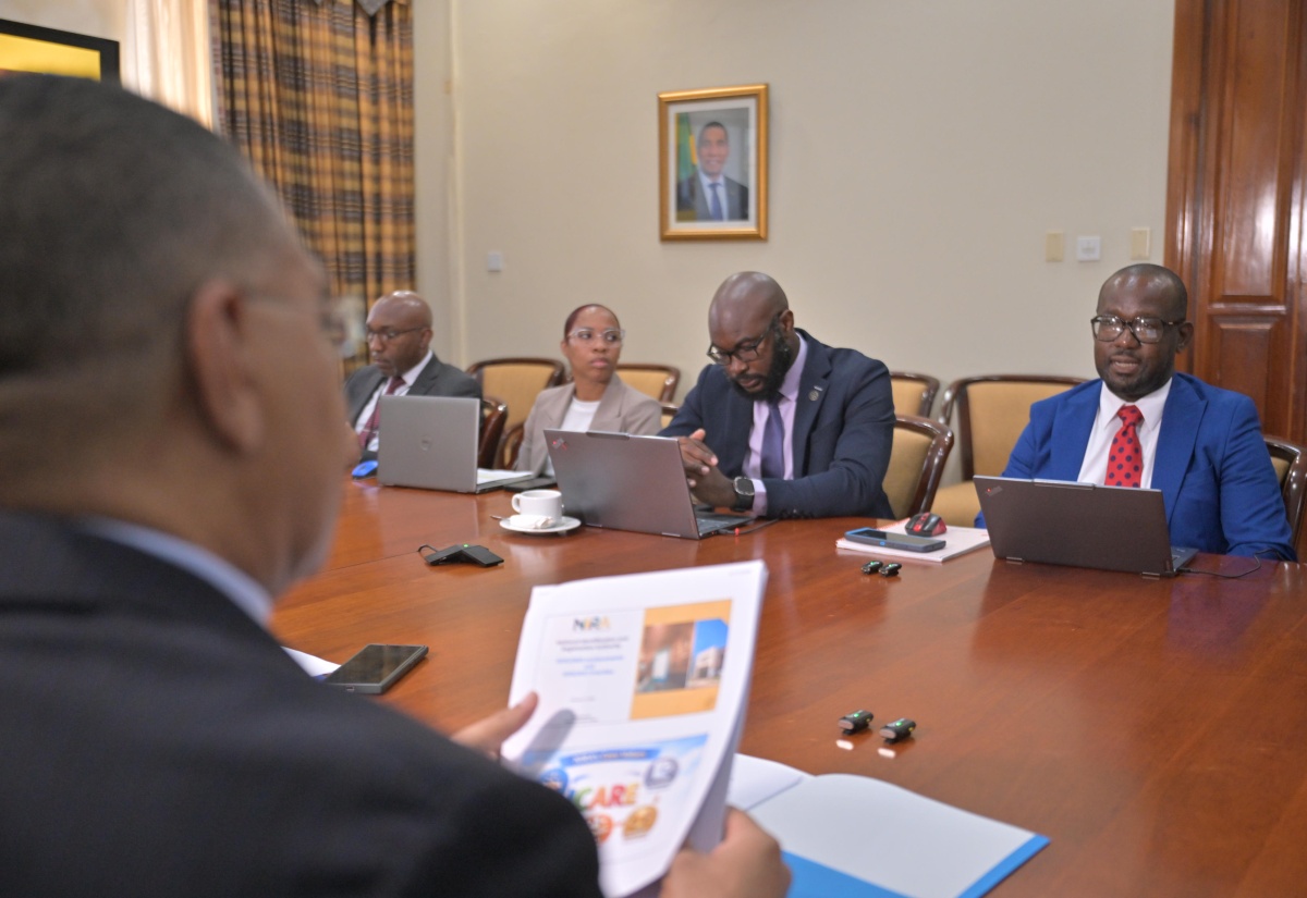 Prime Minister, Dr. the Most Hon. Andrew Holness (left), listens attentively to Executive Director of the National Identification and Registration Authority (NIRA), Dr. Warren Vernon (right), during a meeting held recently at the Office of the Prime Minister.

