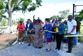 Minister of Culture, Gender, Entertainment and Sport, Hon. Olivia Grange (third left), cuts the ribbon on Friday (March 13) to officially open two African-style houses constructed by the Ghana Army Engineer Reconstruction Team at Seville Heritage Park in St. Ann. She is joined by (from second left): Minister of Water, Environment and Climate Change and Member of Parliament for St. Ann North Eastern, Hon. Matthew Samuda; Minister of Foreign Affairs and Foreign Trade, Senator the Hon. Kamina Johnson Smith; State Minister in the Ministry of Health and Wellness and Member of Parliament for St. Ann North Western, Hon. Krystal Lee; and Mayor of St. Ann’s Bay, Councillor Michael Belnavis. The ceremony also included the Charles Town Maroons and other stakeholders.