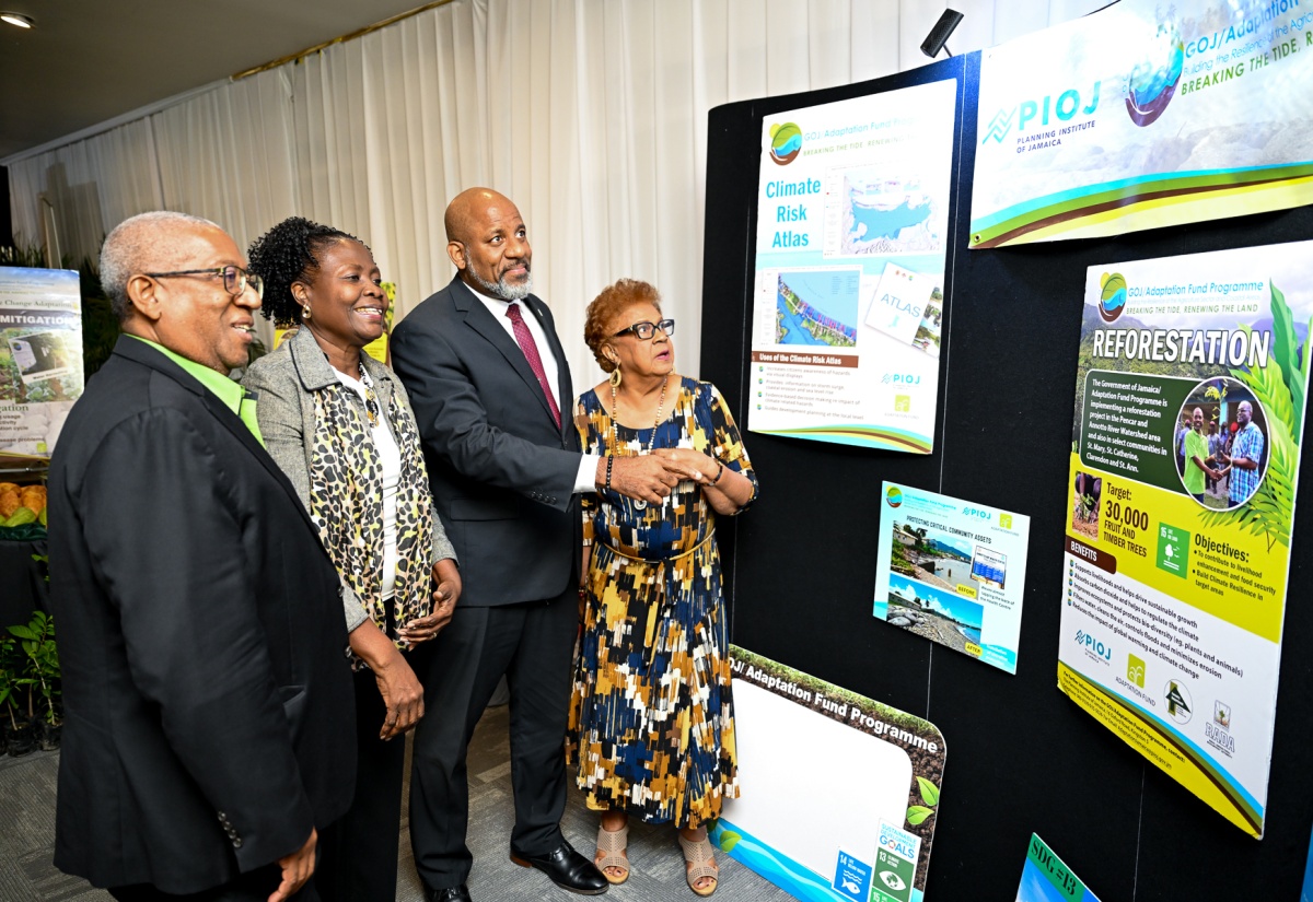 Special Envoy for Climate Change, Professor Dale Webber (left), looks at the exhibition of the various projects completed under the Government of Jamaica/Adaptation Fund Programme (GOJ/AFP), at the initiative’s close-out ceremony, held at the Summit in Kingston on Tuesday (March 24). He is joined by (from left) Programme Manager for the GOJ/AFP, Planning Institute of Jamaica (PIOJ), Shelia McDonald-Miller; Director General of the PIOJ, Dr. Wayne Henry and Member of the Programme’s Steering Committee, Eleanor Jones.  The programme, which was implemented in 2013, has achieved or surpassed its various objectives associated with increasing climate resilience in Jamaica.

