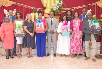 Minister of Labour and Social Security, Hon. Pearnel Charles Jr. (fourth right), is joined by State Minister in the Ministry, Hon. Donovan Williams (background left); Permanent Secretary in the Ministry of Labour and Social Security, Colette Roberts Risden, currently on special assignment providing strategic oversight for the Overseas Employment Programmes in Canada and the United States (third left); Acting Permanent Secretary in the Ministry, Dione Jennings (second right); along with other stakeholders and participants in the Seasonal Agricultural Workers Programme. The occasion was the commemorative thanksgiving service marking the programme’s 60th anniversary at the New Town Power of Faith Deliverance Ministry in New Town Phase II, Hayes, Clarendon, on Sunday (March 29).

