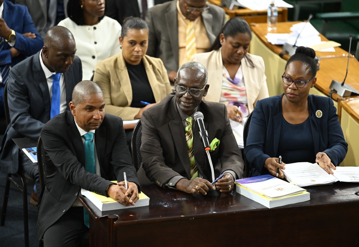 Minister of Local Government and Community Development, Hon. Desmond McKenzie (centre, front row), responds to questions on March 6 during a meeting of the Standing Finance Committee of the House of Representatives at Gordon House, where members were reviewing the 2026/27 Estimates of Expenditure. He is joined by State Minister, Hon. Delroy Williams (left, front row); Permanent Secretary Marsha Henry-Martin (right, front row), and other representatives from the Ministry.


