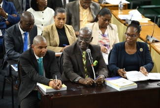 Minister of Local Government and Community Development, Hon. Desmond McKenzie (centre, front row), responds to questions on March 6 during a meeting of the Standing Finance Committee of the House of Representatives at Gordon House, where members were reviewing the 2026/27 Estimates of Expenditure. He is joined by State Minister, Hon. Delroy Williams (left, front row); Permanent Secretary Marsha Henry-Martin (right, front row), and other representatives from the Ministry.


