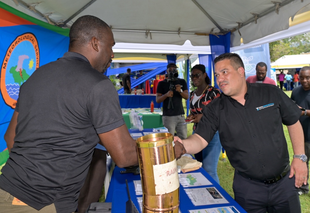 Minister of Water, Environment and Climate Change, Hon. Matthew Samuda (right), greets Meteorological Technician at the Meteorological Service of Jamaica,  Lerone Lynch, during a stop at the agency’s display booth at the World Water Day Exposition 2026 held on Friday (March 20), at the University of the West Indies (UWI), Mona Campus in St. Andrew.