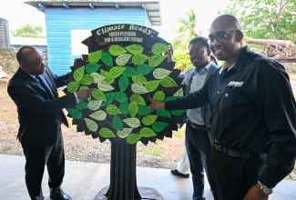 National Environment and Planning Agency (NEPA) Chief Executive Officer (CEO), Leonard Francis (left); Principal of Titchfield High School in Port Antonio, Richard Thompson (centre), and Island Car Rentals CEO, Ryan Parkes, view a display mounted during the National Schools Environmental Clubs Student Workshop hosted by NEPA at the school on March 6.

