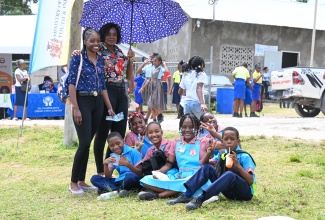 Teachers Tashmarie Rhoden (left) and Ozzette McKoy share a moment with students of Zion Hill Primary during the St. Mary Maths Expo at Galina Primary and Infant School on March 27.
