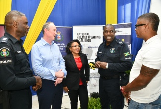 Assistant Commissioner of Police (ACP), Dr. Gary McKenzie (second right), converses with (from left) Commanding Officer, Public Safety and Traffic Enforcement Branch (P-STEB), Senior Superintendent of Police, Lloyd Darby; Chief Executive Officer, Global Road Safety Partnership (GRSP), Dave Cliff; Jamaica National (JN) Foundation General Manager, Claudine Allen; and President, Jamaica Motorcyclist Association (JMA) and Community Engagement National Helmet Wearing Coalition Lead, Marlon Fletcher. The occasion was the Jamaica Constabulary Force (JCF) Helmet Enforcement Training at the Jamaica Defence Force (JDF) Area Four Headquarters (Harman Barracks) on South Camp Road in Kingston on Wednesday (March 25).

