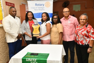 President, Rotary Club of Trafalgar New Heights, Franchesca Francis (second left), presents an Automated External Defibrillator (AED) to Medical Officer, Duhaney Park Health Centre, Dr. Wendy-Ann Byfield-Lyons (third left), at the health facility in St. Andrew on March 27. Sharing the moment (from left) are Assistant District Governor, Rotary District 7020, Karsten Johnson; Public Health Nurse, Winnifred Sterling-McKenzie; District Governor, Rotary District 7020, Professor William Aiken; and Consultant Medical Officer of Health,  Dr. Audre McIntosh. The defibrillator,  valued at US$2,500, will significantly enhance emergency preparedness and strengthen community health.
