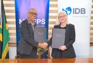 Minister of Finance and the Public Service, Hon. Fayval Williams (left), and Inter-American Development Bank (IDB) Country Representative in Jamaica, Natacha Marzolf, exchange copies of the Loan Contract for the Continued Public Sector Transformation Programme. A Visibility Ceremony to commemorate the loan contract between the Government and the IDB was held at the Ministry of Finance and the Public Service in Kingston on Friday (March 27).