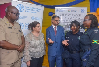 Indian High Commissioner to Jamaica, His Excellency Mayank Joshi (centre), makes a point to Head of the Guanaboa Vale Police, Sergeant Navelette Davis-Leachman (right), and Constable Leonie Angus (second right), during the recent certification ceremony for persons who participated in the Improving Rural Livelihoods Through Resilient Agrifood Systems Project, held at the Spring Village Community Centre in St. Catherine.  Sharing in the conversation are Commanding Officer of the Jamaica Constabulary Force (JCF) Agricultural Protection Branch (APB), Senior Superintendent of Police (SSP) Oral Pascoe (left), and Food and Agriculture Organization of the United Nations (FAO) Representative for Jamaica, The Bahamas and Belize, Dr. Ana Touza.
